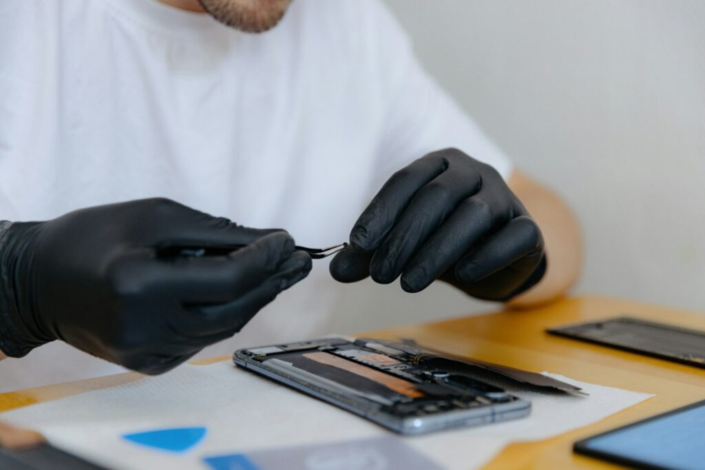 A young man repairs a smartphone at home.