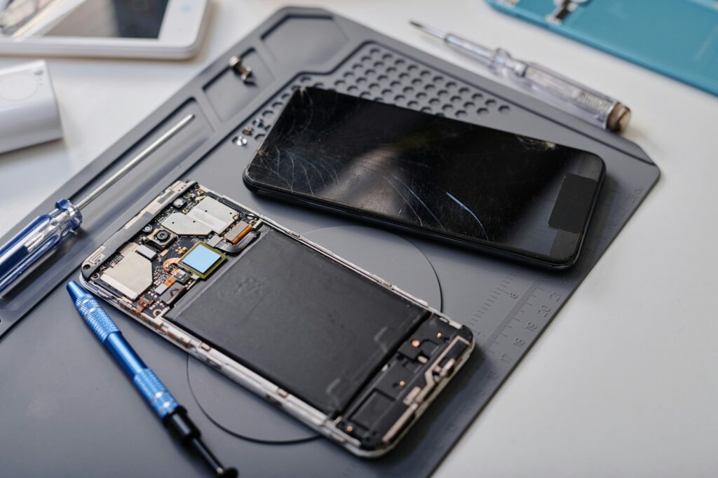 Two Damaged Phones Displayed on Table in Electronic Repair Workshop